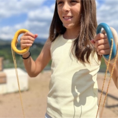 Corda de saltar colorida nas mãos de criança ao ar livre.
