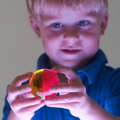 Menino segurando bola colorida translúcida