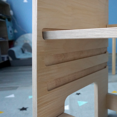 Detalhe de móvel de madeira clara com ranhuras horizontais e recorte em arco