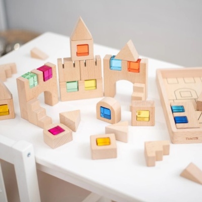 Blocos de madeira com janelas coloridas em plástico numa mesa branca