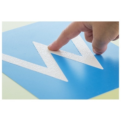 Autocolante azul com letra W branca em relevo tocado por um dedo humano