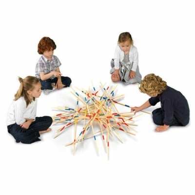 Quatro crianças sentadas jogando jogo de pauzinhos coloridos em fundo branco