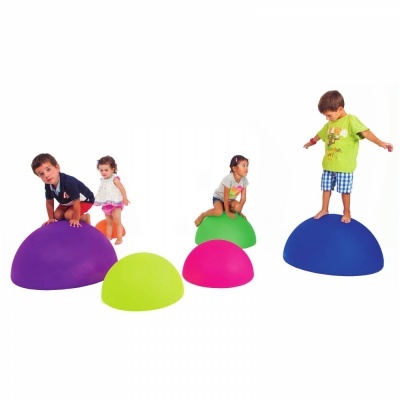 Crianças a brincar em montes semi-esféricos coloridos de plástico