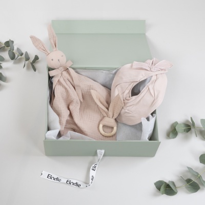 Conjunto de presente para bebé em caixa verde com brinquedo de coelho e tecido rosa