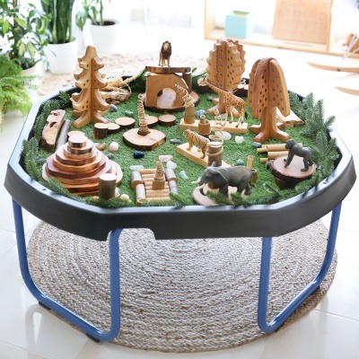 Mesa de brincadeira com brinquedos de madeira sobre relva artificial