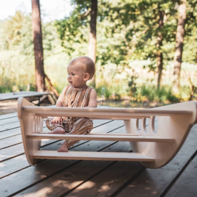 Cadeira para bebé bege em varanda de madeira ao ar livre