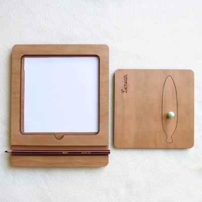 Conjunto de escrita em madeira com bloco de notas, lápis e tabuleiro com recorte de prancha de surf.