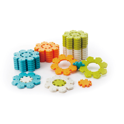 Peças de plástico coloridas em forma de flores, empilhadas e espalhadas, em fundo branco