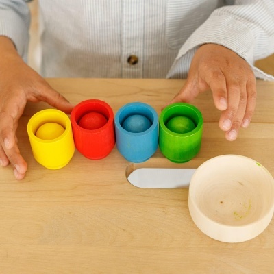 Cubos de madeira coloridos com bolas, prato e espátula em mesa de madeira