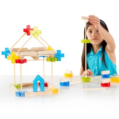 Menina a brincar com um conjunto de construção com peças coloridas