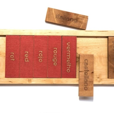 Blocos de madeira com palavras em várias línguas organizados numa base de madeira clara