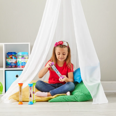 Menina numa tenda branca com tubos e ampulhetas coloridas