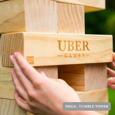 Blocos de madeira claros empilhados em jogo de torre, com mãos a mexer os blocos