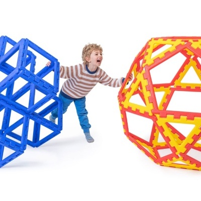 Criança a brincar com estruturas geométricas grandes de brinquedo
