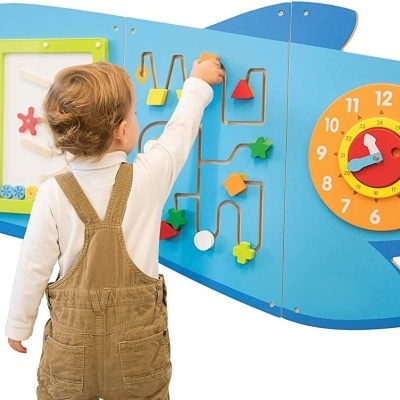 Painel infantil em forma de tubarão azul com relógio e jogos lúdicos, criança a brincar