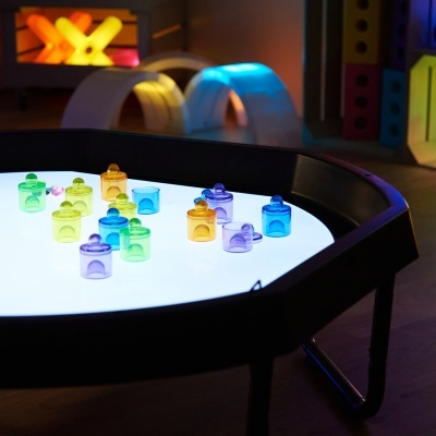 Mesa sensorial luminosa com peças coloridas de plástico translúcido