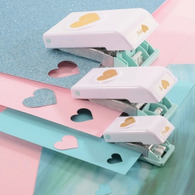 Furadores de papel com recortes em forma de coração em folhas coloridas