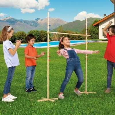 Crianças a jogar limbo com estrutura de madeira no jardim