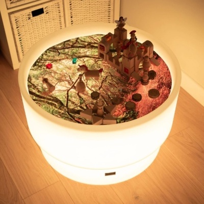 Mesa redonda luminosa com figuras de madeira decorativas