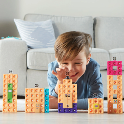 Blocos de construção coloridos empilhados com números e criança brincando em sala