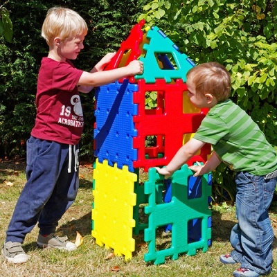 Crianças a montar brinquedo de construção colorido ao ar livre