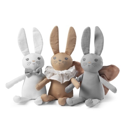 Três bonecos de coelho de peluche com diferentes acessórios e cores