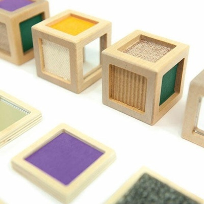 Cubos de madeira coloridos e texturizados com janelas transparentes sobre fundo branco