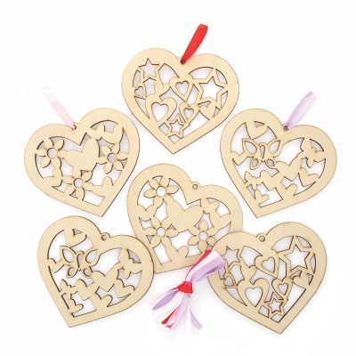 Ornamentos de madeira em forma de coração com fita colorida.