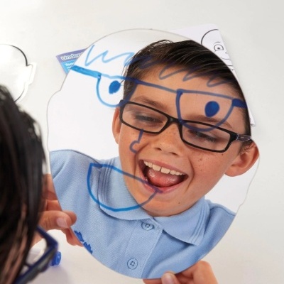 Menino sorridente com espelho e desenho azul sobreposto no rosto