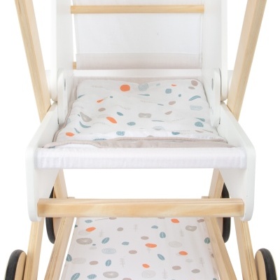 Carrinho de bebé de madeira clara com tecido branco estampado com formas coloridas.