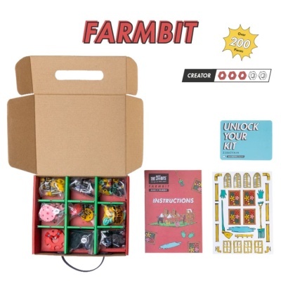 Kit de montagem em caixa aberta com peças coloridas, manual, cartão e folhas com imagens para construção.