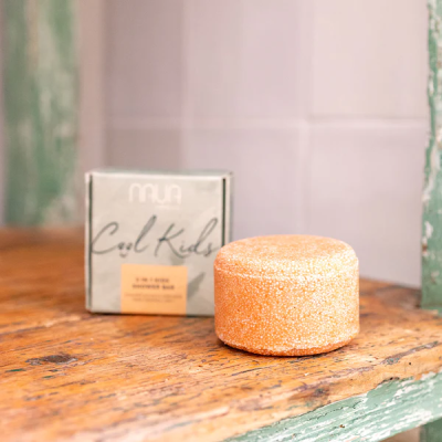 Barra sólida laranja para cabelo com embalagem cinza em madeira rústica