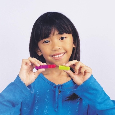 Criança com camisa azul segurando blocos coloridos