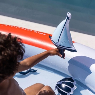 Barco insuflável azul e branca sendo segurado por criança numa piscina insuflável