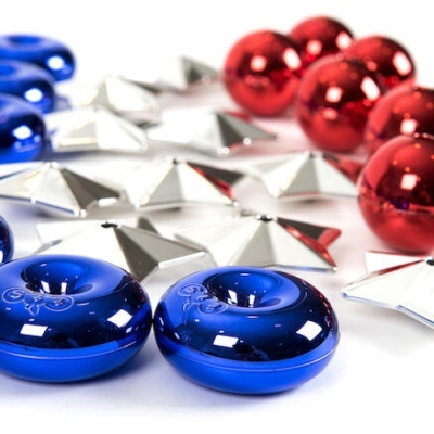 Decorações metálicas azuis, vermelhas e prateadas sobre superfície branca