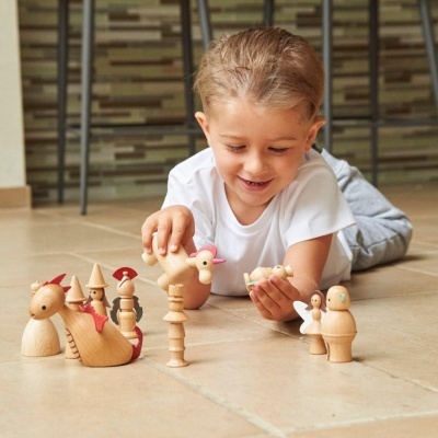 Criança a brincar com figuras de madeira coloridas no chão