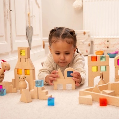 Criança a brincar com blocos de madeira coloridos em ambiente interior
