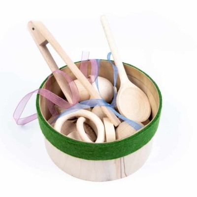 Utensílios de cozinha em madeira dentro de recipiente com fita verde