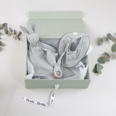 Conjunto para bebé com chupeta de pano cinza em forma de coelho e babete cinza em caixa aberta