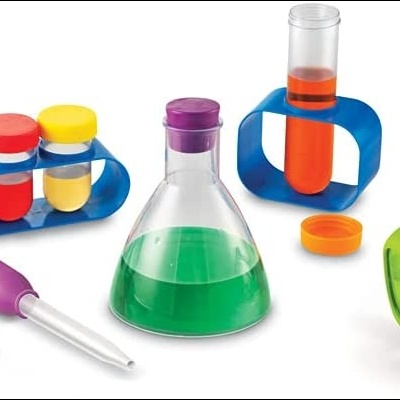 Brinquedo de laboratório plástico colorido com funil, óculos, béquer, frascos e tubos de ensaio.