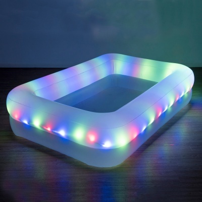 Piscina insuflável branca com luzes LED coloridas numa sala com parede azul