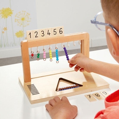 Brinquedo educativo de madeira com contas coloridas e números usados por criança