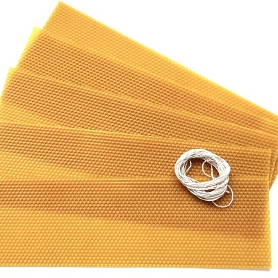 Folhas de cera de abelha amarelas com pavio branco em fundo branco