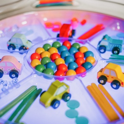 Jogo infantil colorido com carrinhos de madeira, bolas multicoloridas e luzes LED