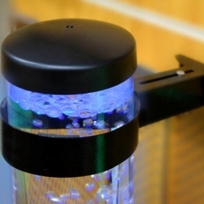 Dispositivo cilíndrico com luz azul e bolhas, tampa preta e fixação preta