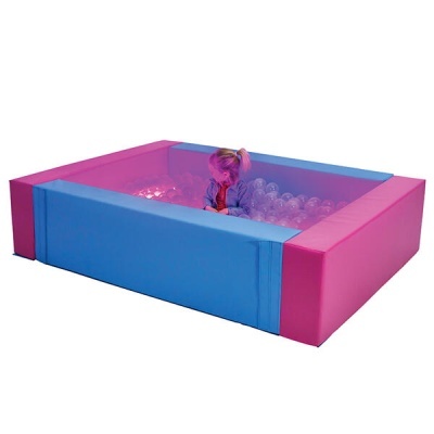 Piscina de bolas retangular azul e rosa com bolas transparentes dentro e criança sentada