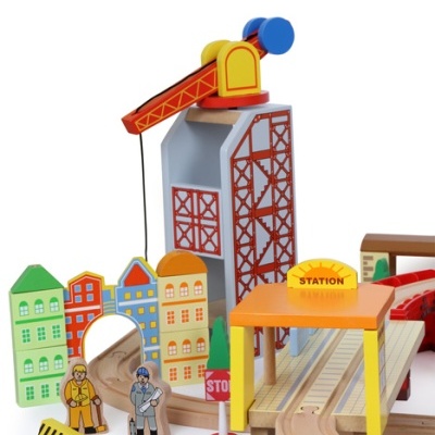 Brinquedo ferroviário de madeira colorido com grua, casas, figuras e plataforma com sinal STATION
