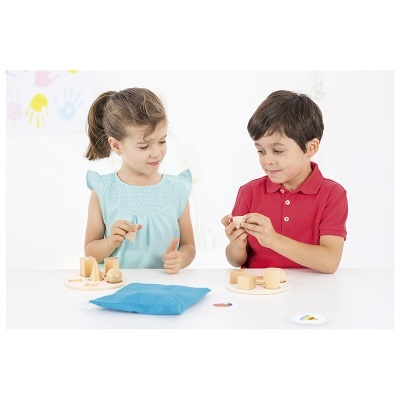 Crianças a brincar com blocos de madeira numa mesa branca