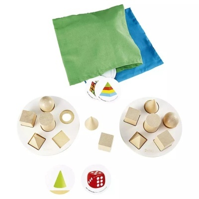 Conjunto de jogo com peças geométricas de madeira, sacos verdes e azuis, cartas coloridas e dado vermelho.