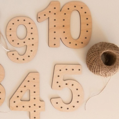 Números de madeira com furos e novelo de fio de juta